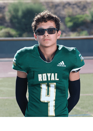 A young man wearing a white and black jersey with the number 14 on it. Description generated by AI