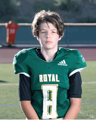 A young man wearing a white and black jersey with the number 14 on it. Description generated by AI