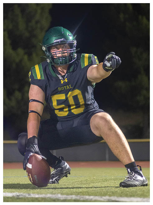 Two football players wearing black jerseys and holding hands. Description generated by AI