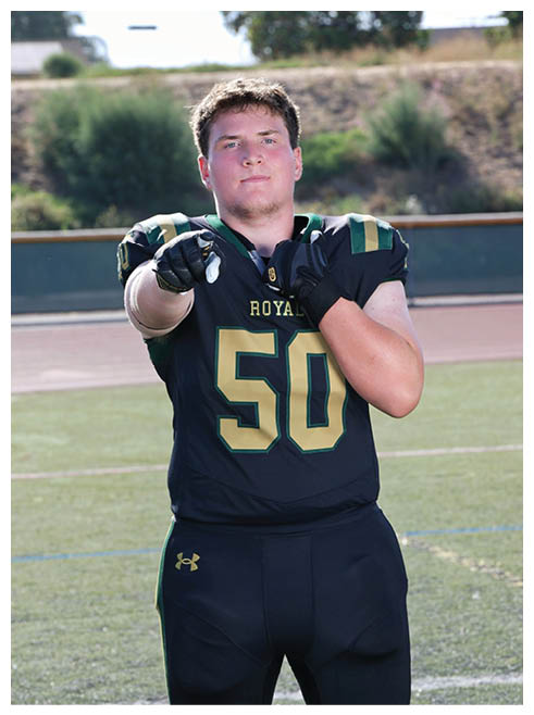 Two football players wearing black jerseys and holding hands. Description generated by AI