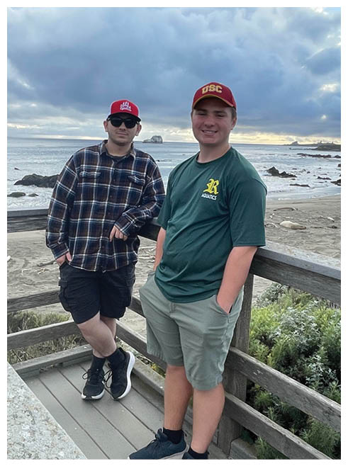 Two football players wearing black jerseys and holding hands. Description generated by AI