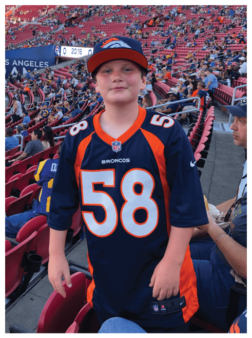 Two football players wearing black jerseys and holding hands. Description generated by AI