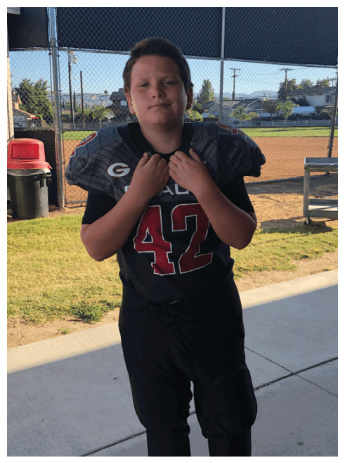 Two football players wearing black jerseys and holding hands. Description generated by AI