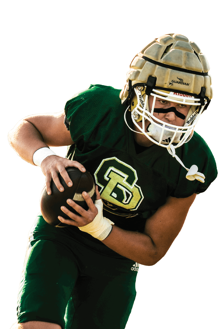 A person wearing a green football uniform and helmet is holding a football tightly while running. Description generated by AI