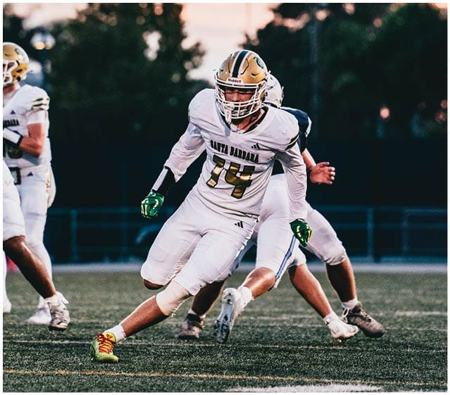 Several people in football uniforms are actively playing on a field during sunset. Description generated by AI