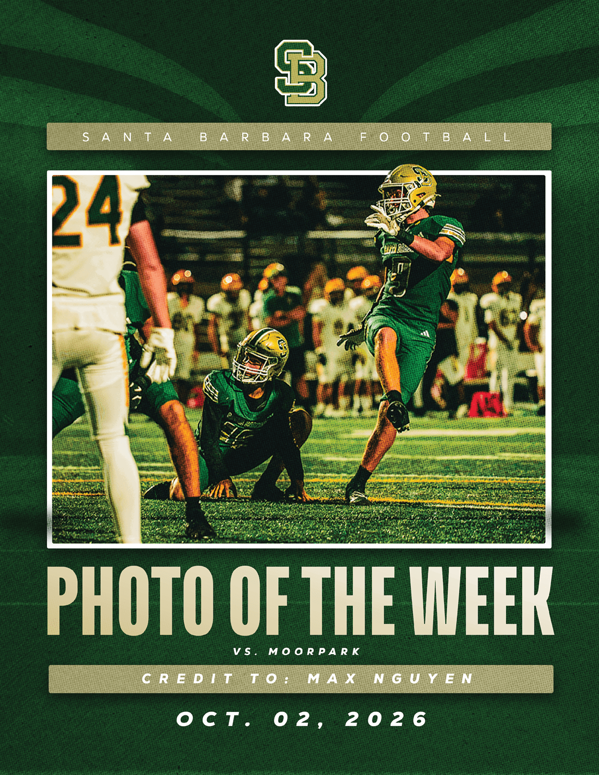 Two football players in green uniforms are on a field during a game against a team in white uniforms, with one player kicking the ball and the other crouching nearby. Description generated by AI