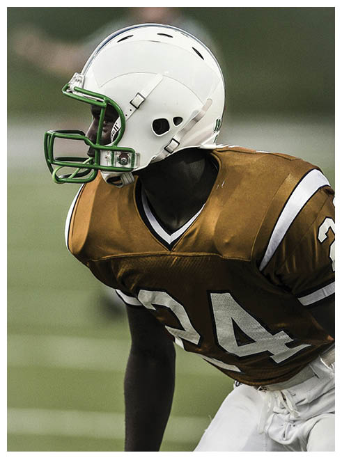A football player wearing a red and white jersey with the number 24 on it. Description generated by AI