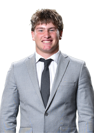 A young man wearing a white and black jersey with the number 14 on it. Description generated by AI