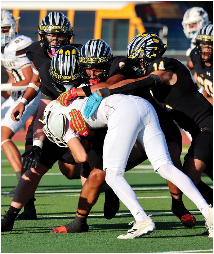 A group of football players wearing black and white uniforms. Description generated by AI