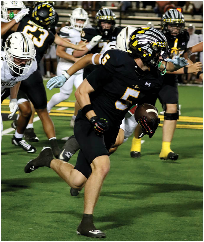 A group of football players wearing black and white uniforms. Description generated by AI