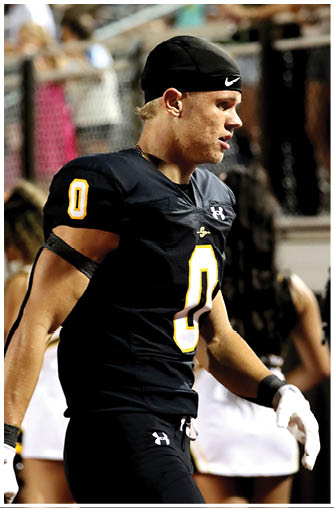 A football player running on the field. Description generated by AI