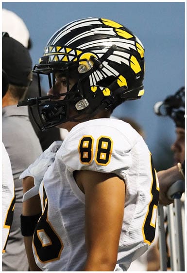 A football player wearing a blue and white uniform. Description generated by AI