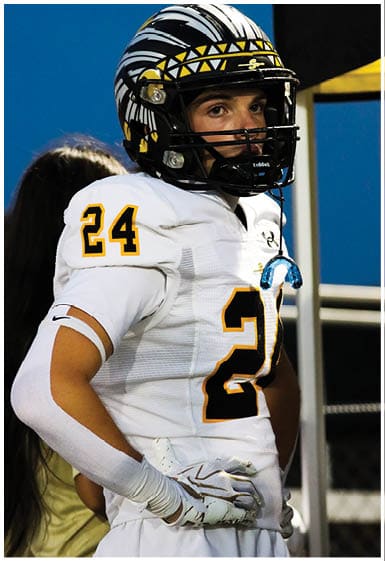 A football player wearing a blue and white uniform. Description generated by AI