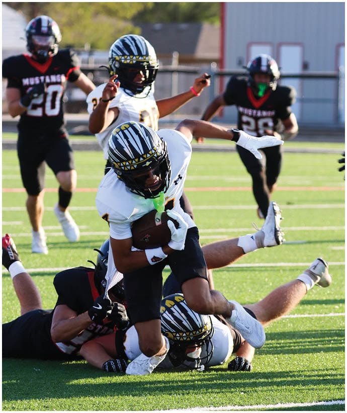A group of football players wearing black and white uniforms. Description generated by AI