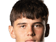 Person with curly hair and light eyes looking forward against a white background. Description generated by AI