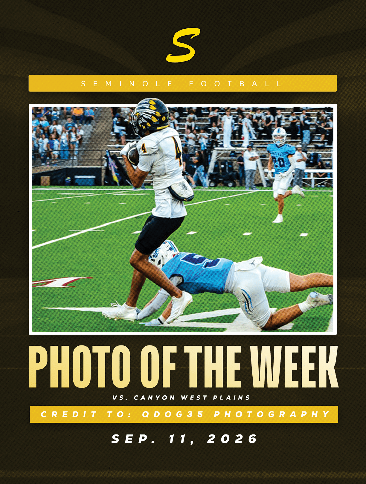 A person in a white and black football uniform is running with the ball while another person in a blue and white uniform is diving on the ground attempting to tackle them on a football field with spectators in the background. Description generated by AI