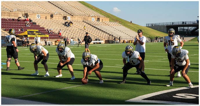 A group of football players on a field. Description generated by AI