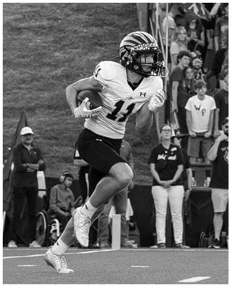 A football player running on the field. Description generated by AI