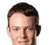 Person with curly hair and light eyes looking forward against a white background. Description generated by AI