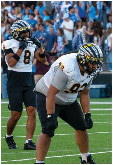 A football player wearing a blue and white uniform. Description generated by AI