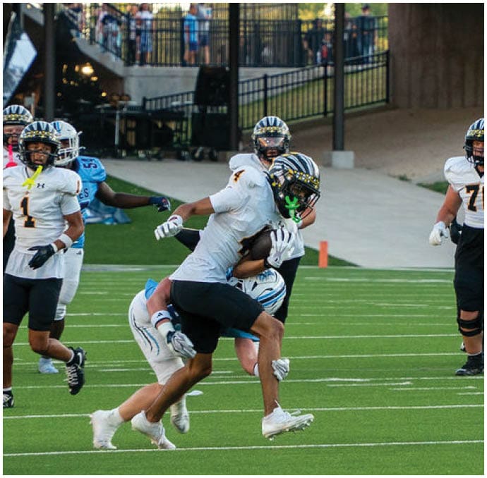A group of football players wearing black and white uniforms. Description generated by AI