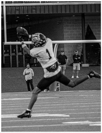 A football player running on the field. Description generated by AI
