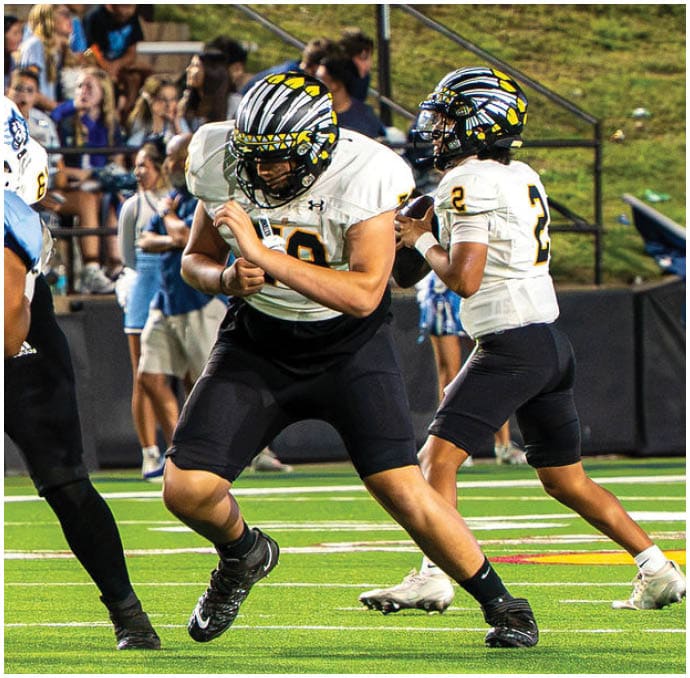 A group of football players wearing black and white uniforms. Description generated by AI