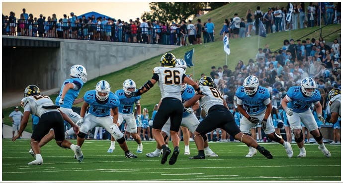 A group of football players on a field. Description generated by AI