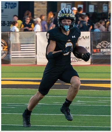 A football player wearing a blue and white uniform. Description generated by AI