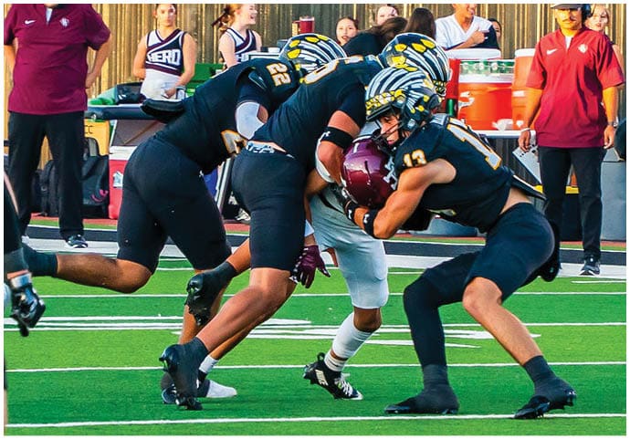 A group of football players wearing black and white uniforms. Description generated by AI