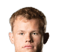Person with curly hair and light eyes looking forward against a white background. Description generated by AI