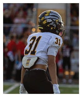Two football players wearing black jerseys and holding hands. Description generated by AI
