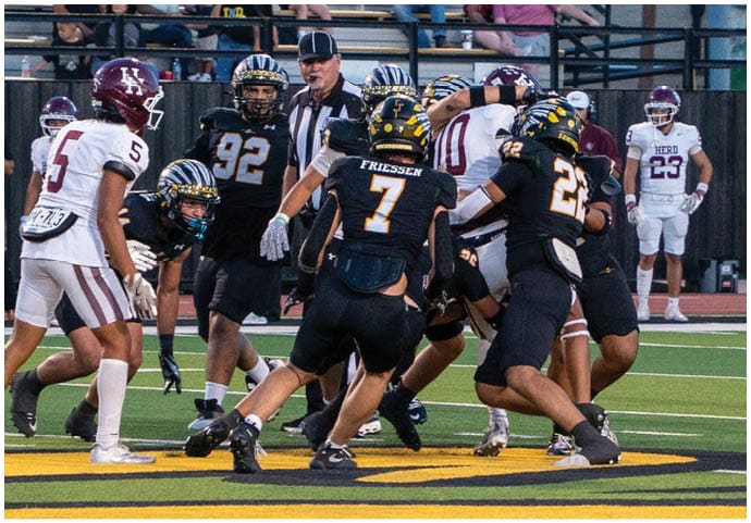 A group of football players wearing black and white uniforms. Description generated by AI