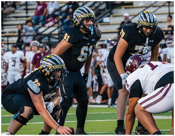 A group of football players on a field. Description generated by AI