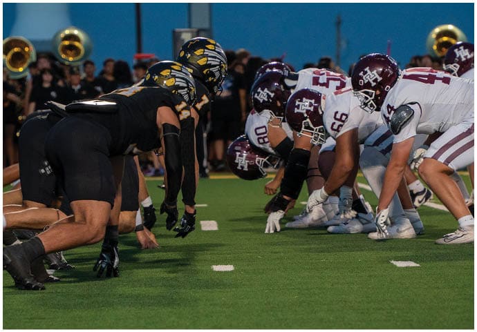 A group of football players wearing black and white uniforms. Description generated by AI