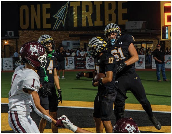A group of football players on a field. Description generated by AI