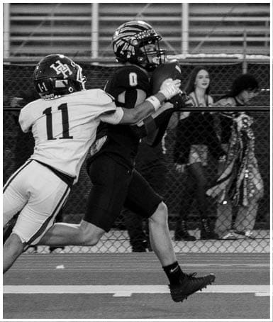 A football player wearing a blue and white uniform. Description generated by AI