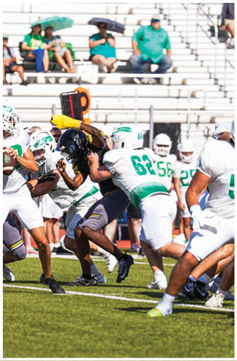 A football player running with a ball. Description generated by AI