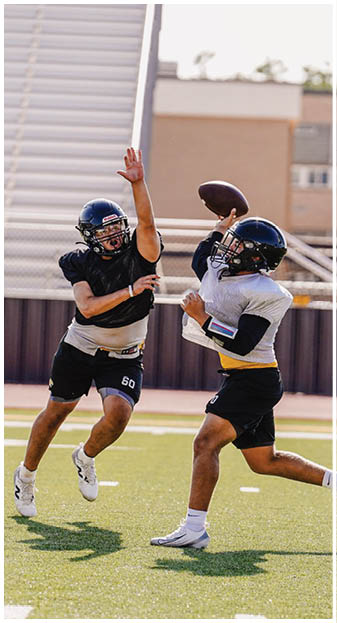 A football player catching a ball. Description generated by AI