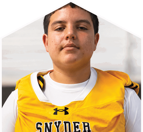 A person wearing a yellow sports jersey with the word “SNYDER" and the number 12 stands in front of a blurred outdoor background. Description generated by AI