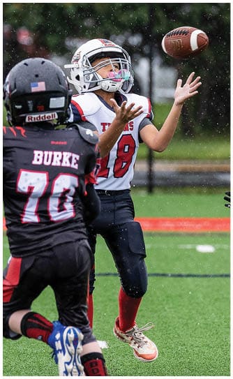 A football player catching a ball. Description generated by AI