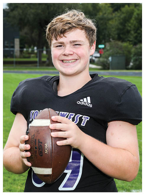 Two football players wearing black jerseys and holding hands. Description generated by AI
