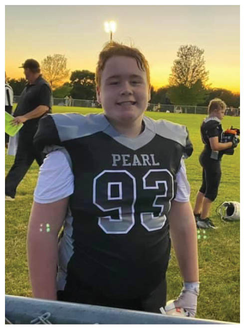 Two football players wearing black jerseys and holding hands. Description generated by AI
