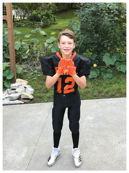 Two football players wearing black jerseys and holding hands. Description generated by AI