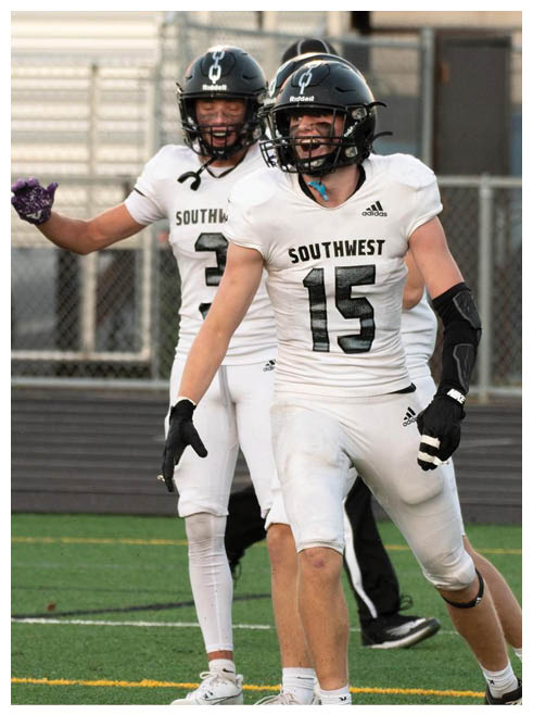 Two football players wearing black jerseys and holding hands. Description generated by AI