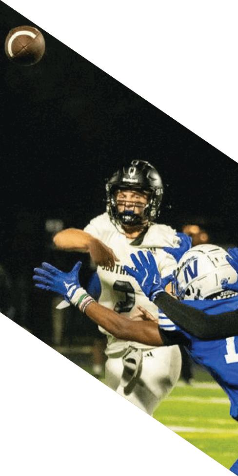 Two men are jumping in the air on a field, both wearing football uniforms. AI generated content
