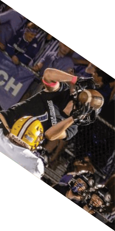 Two football players are on the field, one jumping in the air while the other is running. A referee is also present, watching the play. AI generated content