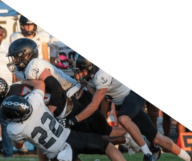 A group of football players kneeling on the field, some with their hands on their heads. AI generated content