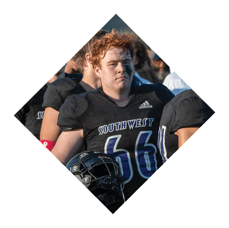A football player wearing a black jersey with the number 3 kneels on the field. AI generated content