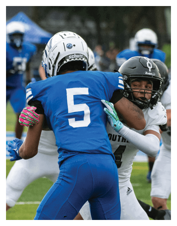 A football player wearing a helmet and white uniform is holding his helmet above his head. AI generated content